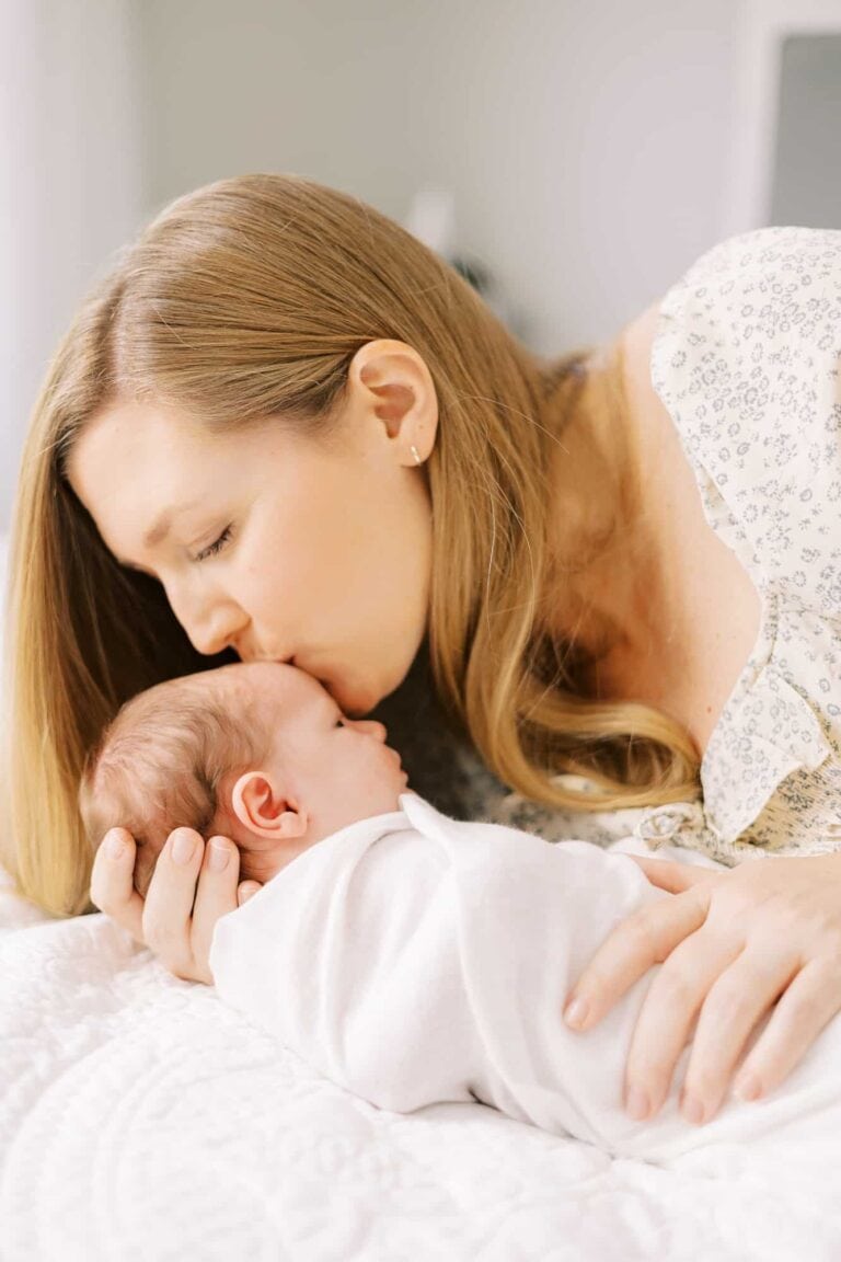 mom kissing newborn girl